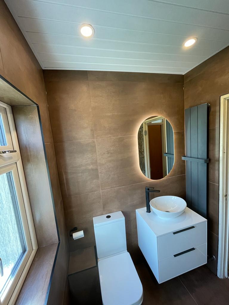 Copper-toned bathroom with sink and window.